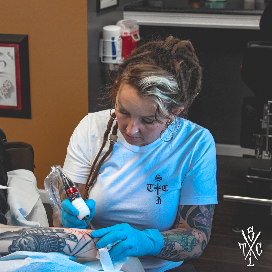 Artist tattooing an arm